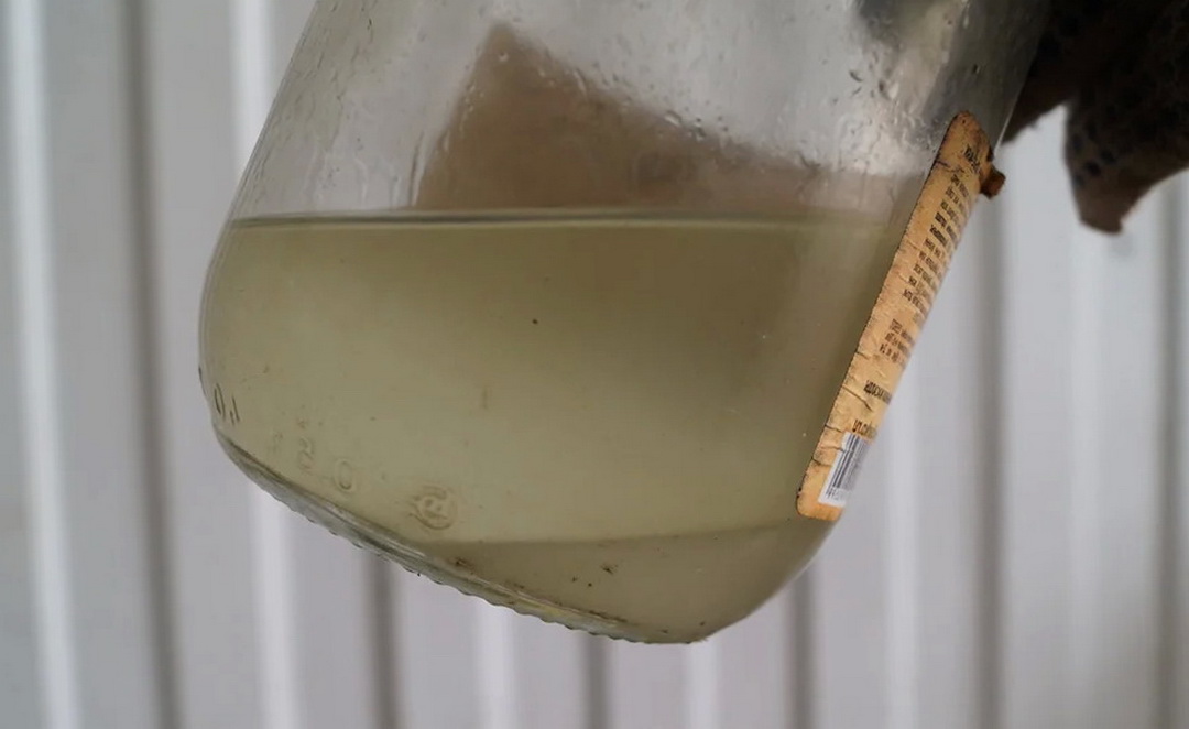 Transparent sediment in a bottle with gasoline - presence of water